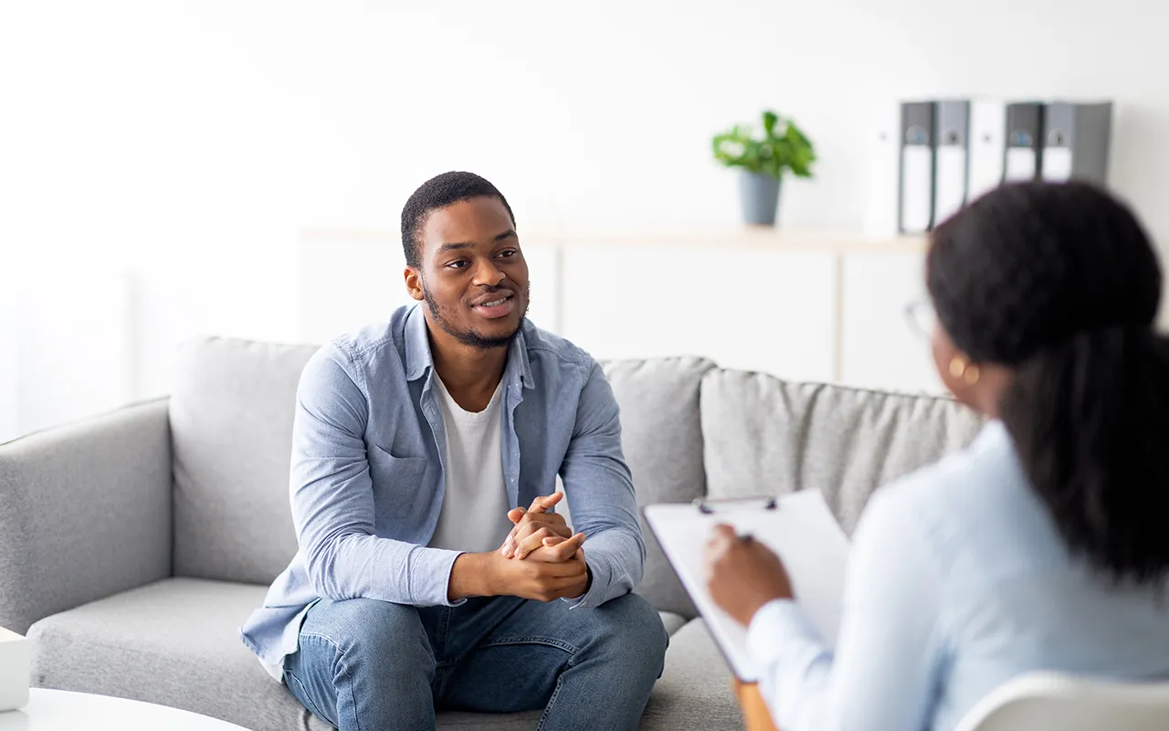 Young man speaking with therapist during counseling session